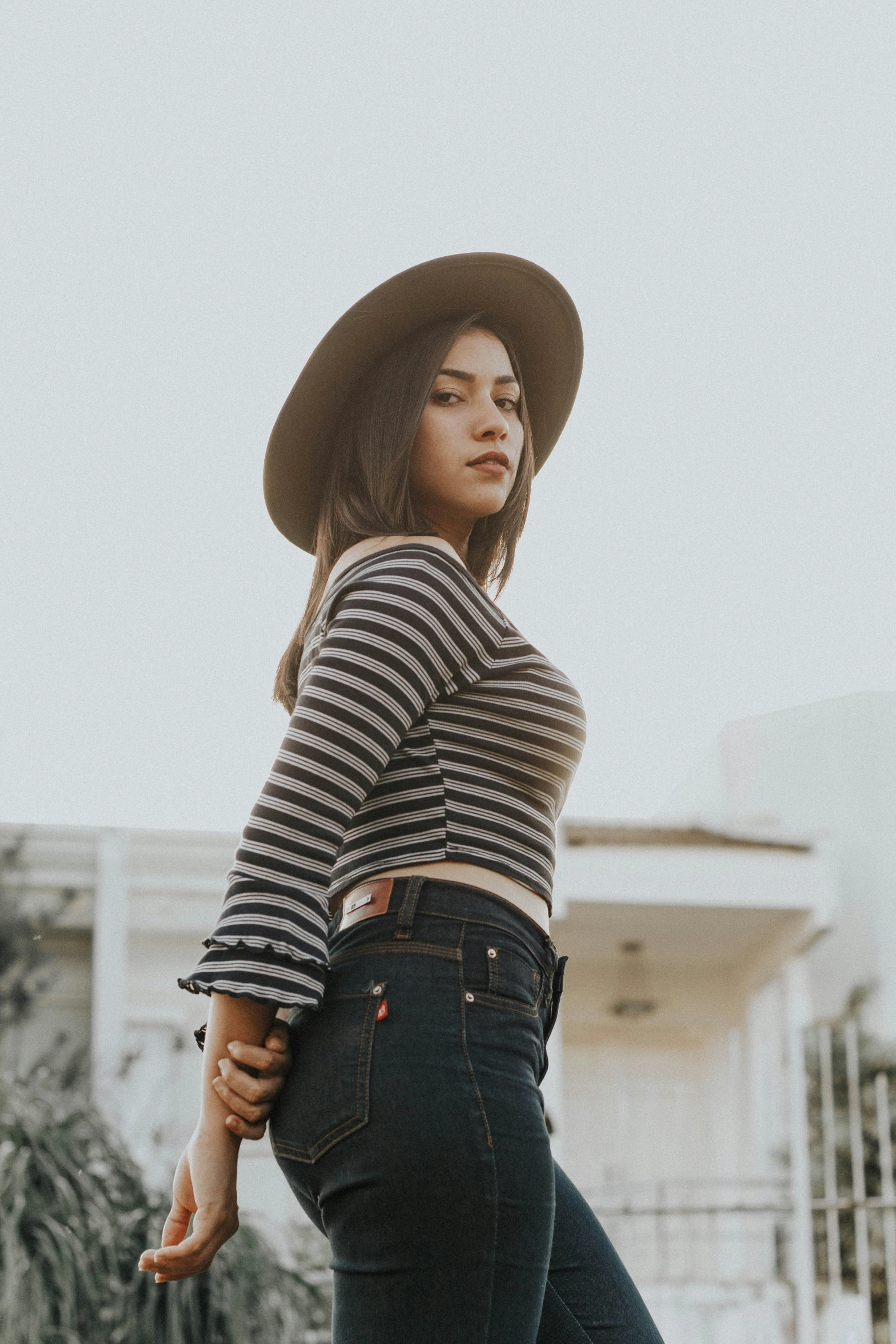 the woman in her top is leaning up against the wall