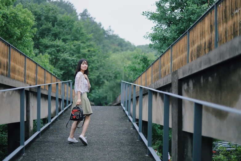 there is a woman that is standing on the bridge