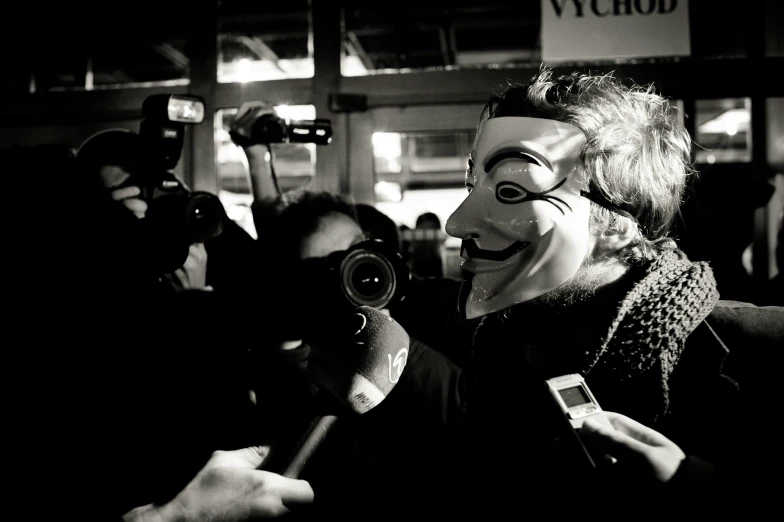 a person wearing a mask while filming people
