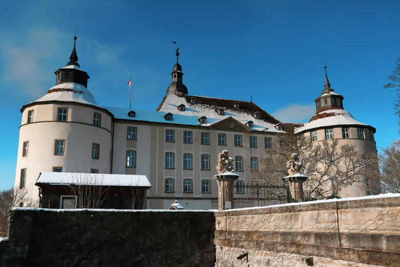 a building surrounded by a wintery tree covered hill