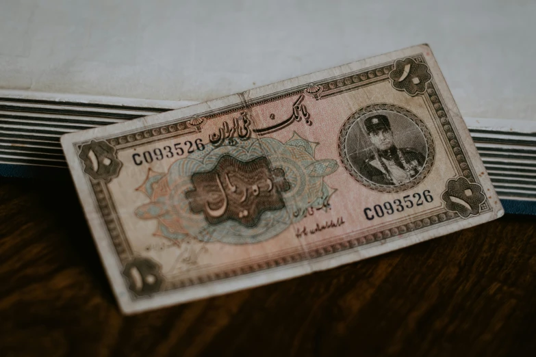 a piece of paper money sitting on top of a wooden table