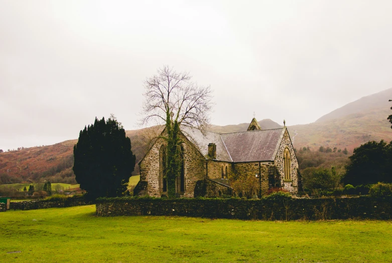 a church sitting on the side of a lush green hillside