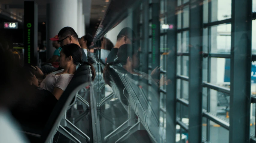 people using their cell phones in a public transportation station