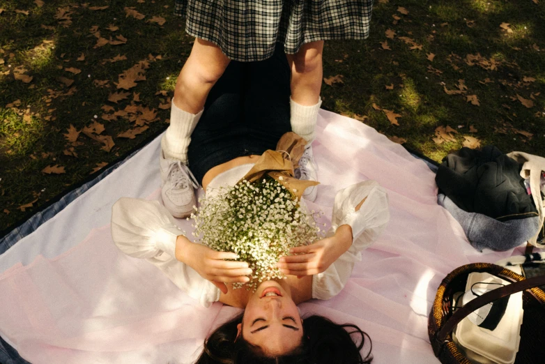 a young woman is laying on the ground with a bouquet of flowers