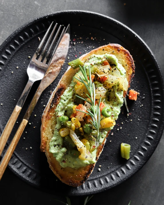 a piece of toast on a plate with vegetables