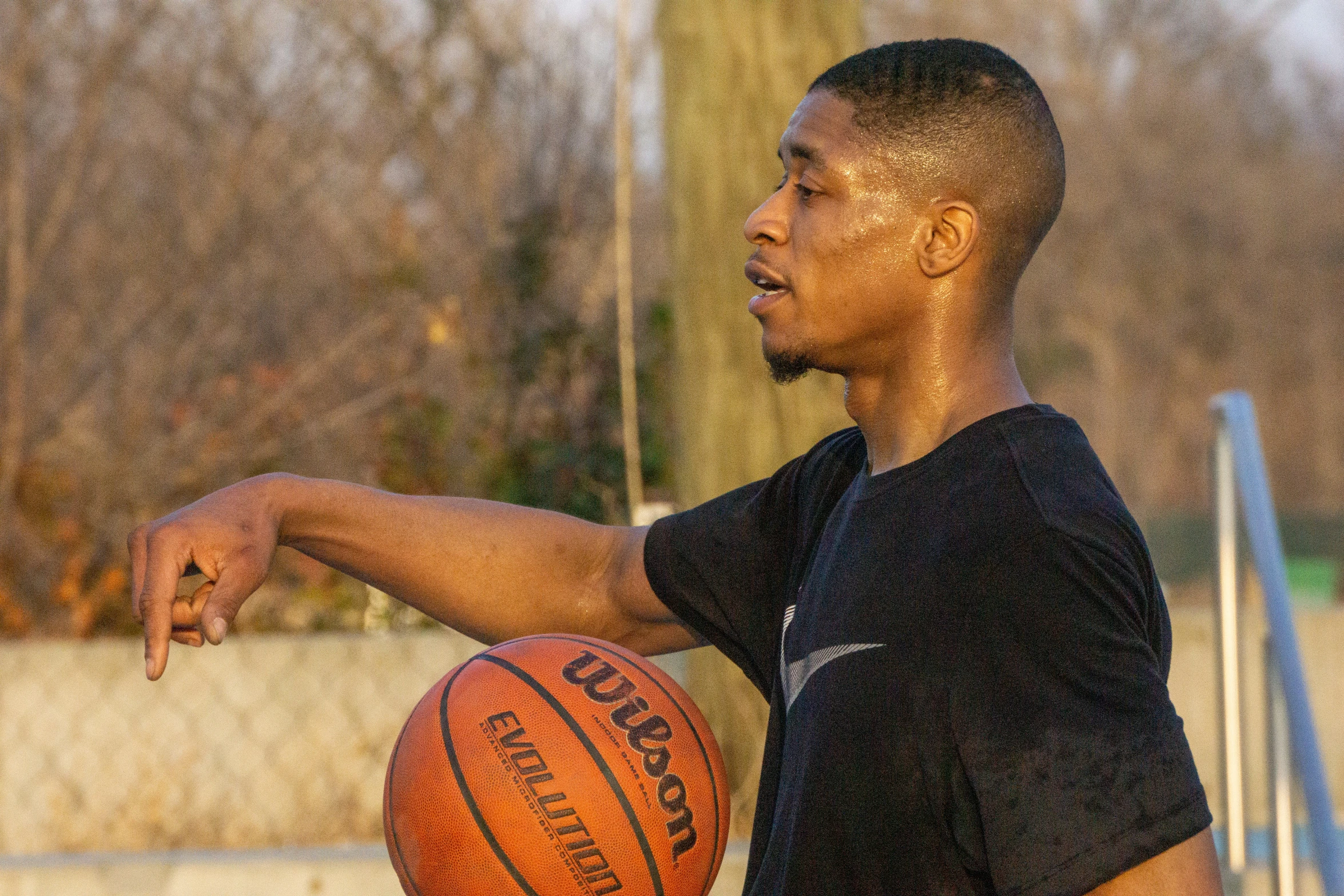 a man holding a basketball while standing in front of a ramp