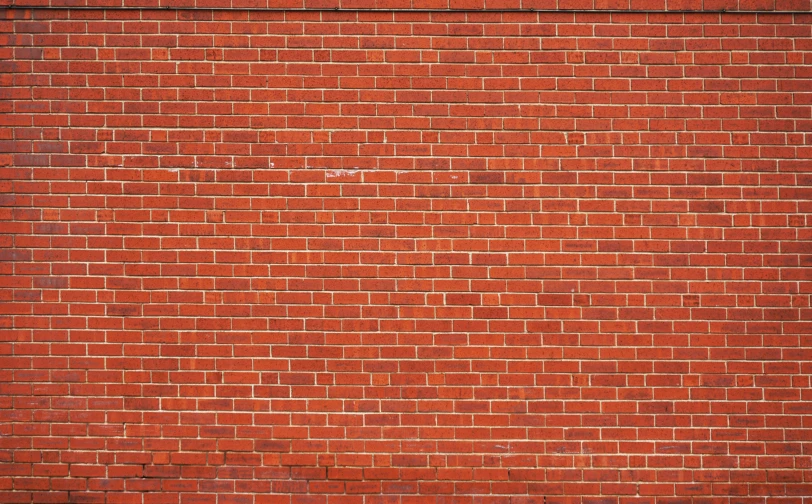 a man is riding a skateboard past a brick wall