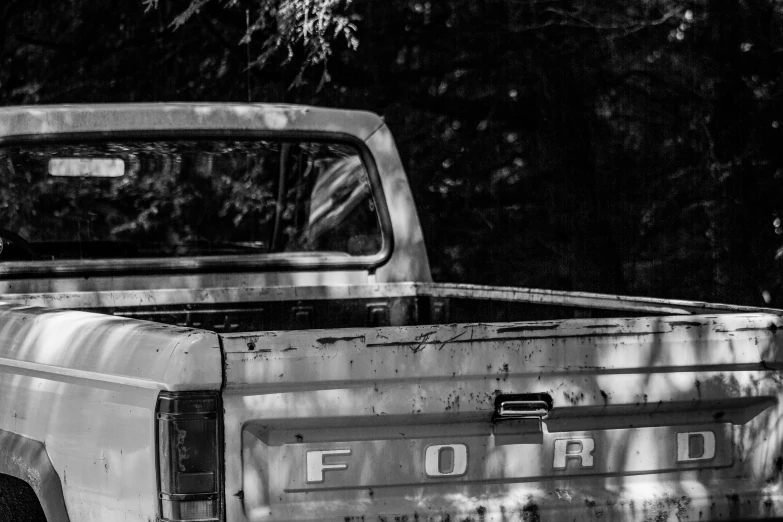 black and white pograph of an old ford pickup truck parked on grass