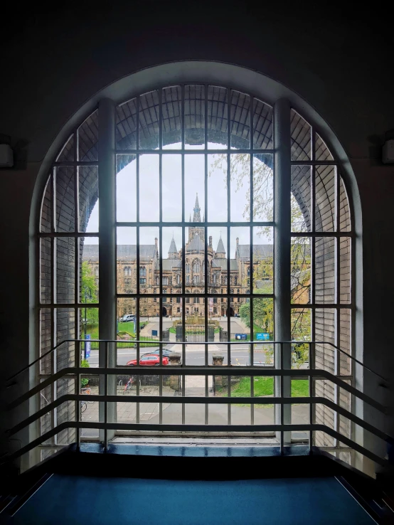 a window view of a large building and cars