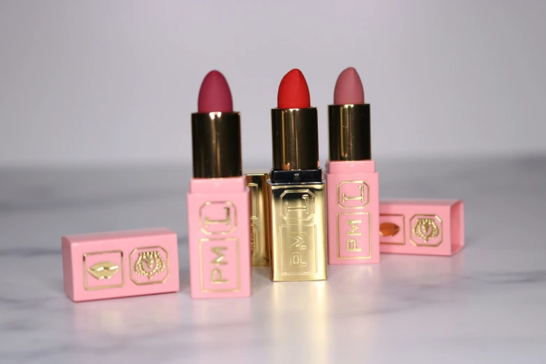 pink lipstick with matching box on light colored surface