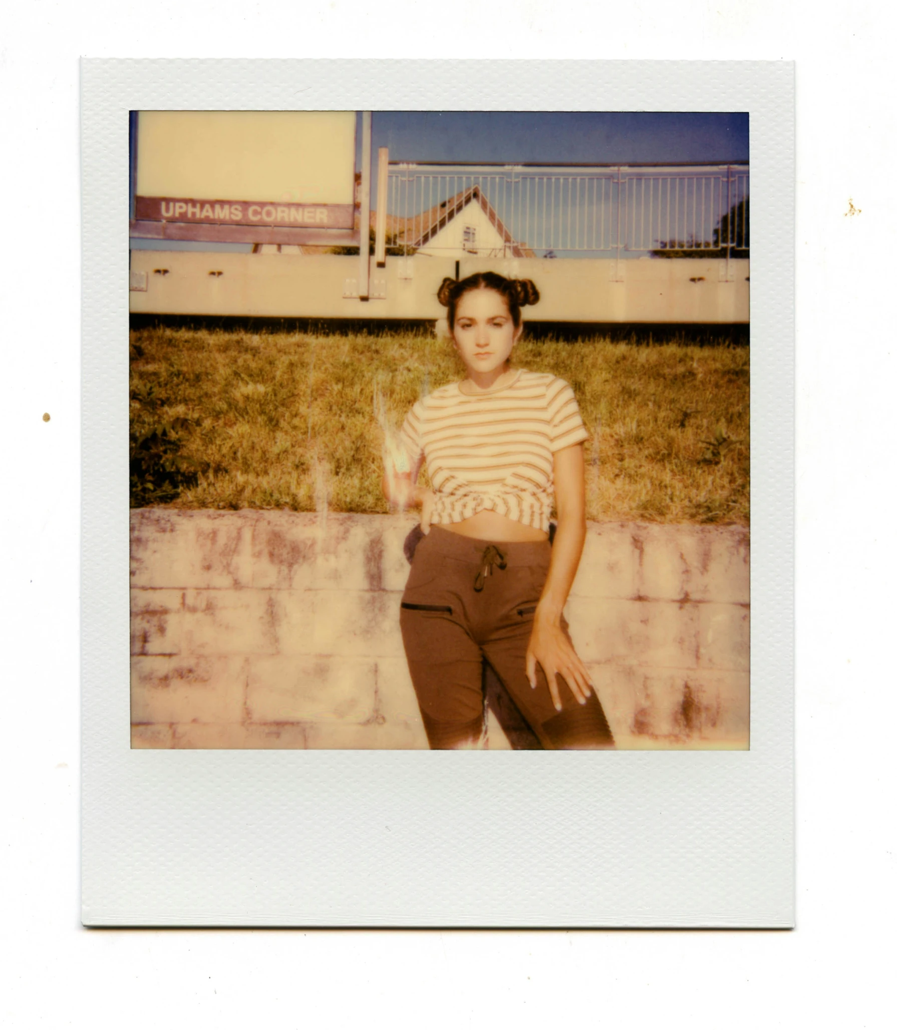 a woman is standing in front of a fence