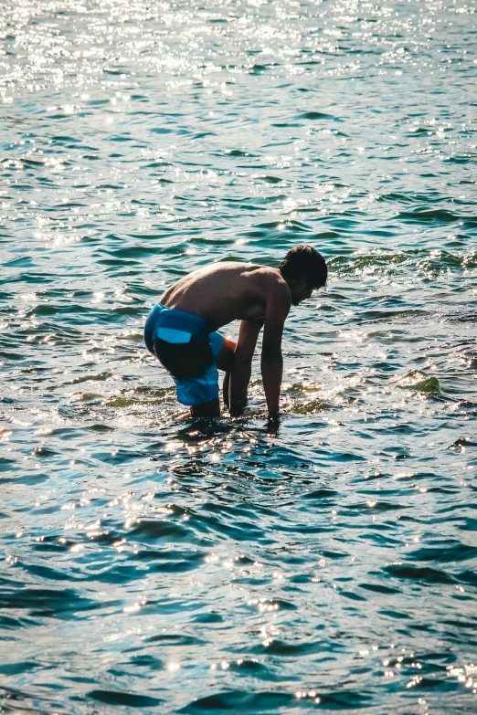 a man is standing in water while holding on to a blue ring