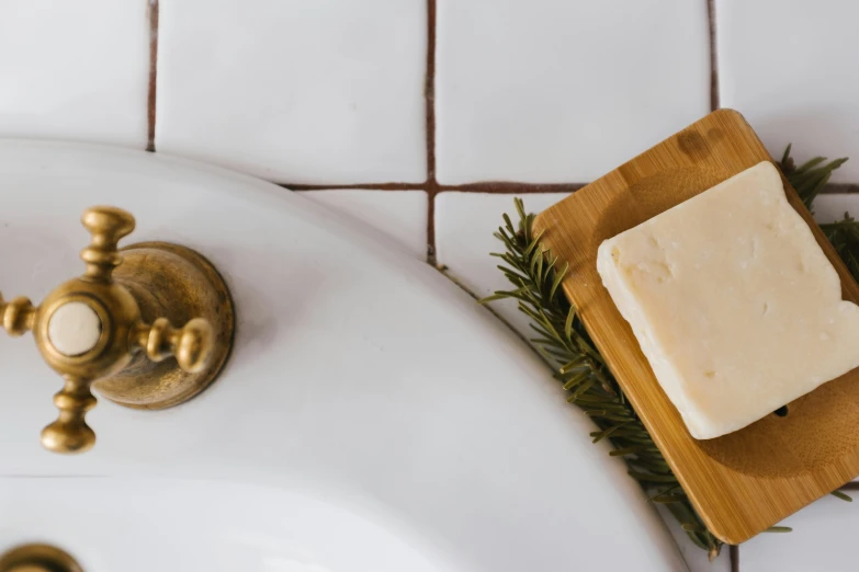 a sink and soap dish with rosemary on the edge