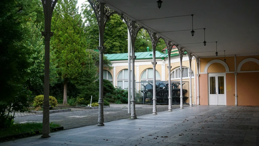 an empty street with white pillars and arches