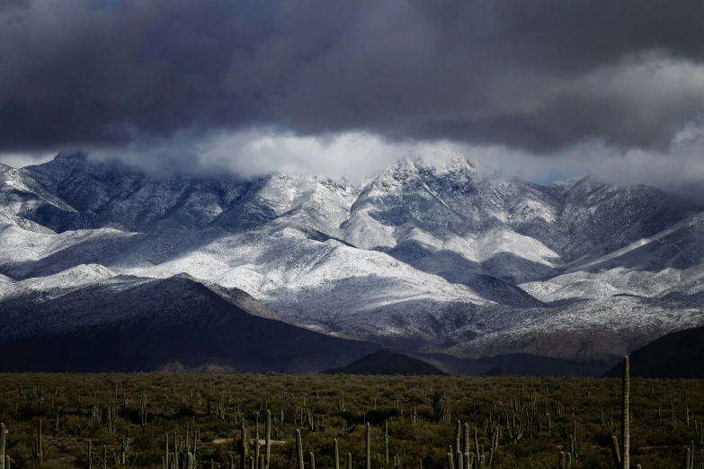 some snow mountains and a sky filled with clouds