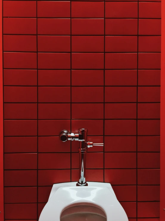 there is a toilet in a bathroom with bright red tile