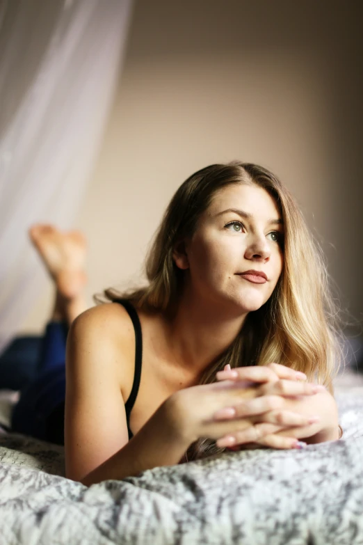 a young woman in a black top is laying down