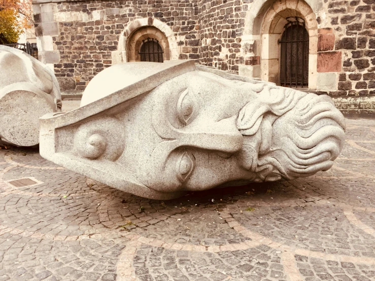 a large stone object in front of a building