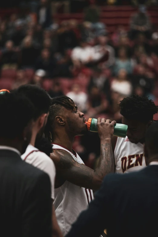 the group of people drink from cups while in the stands