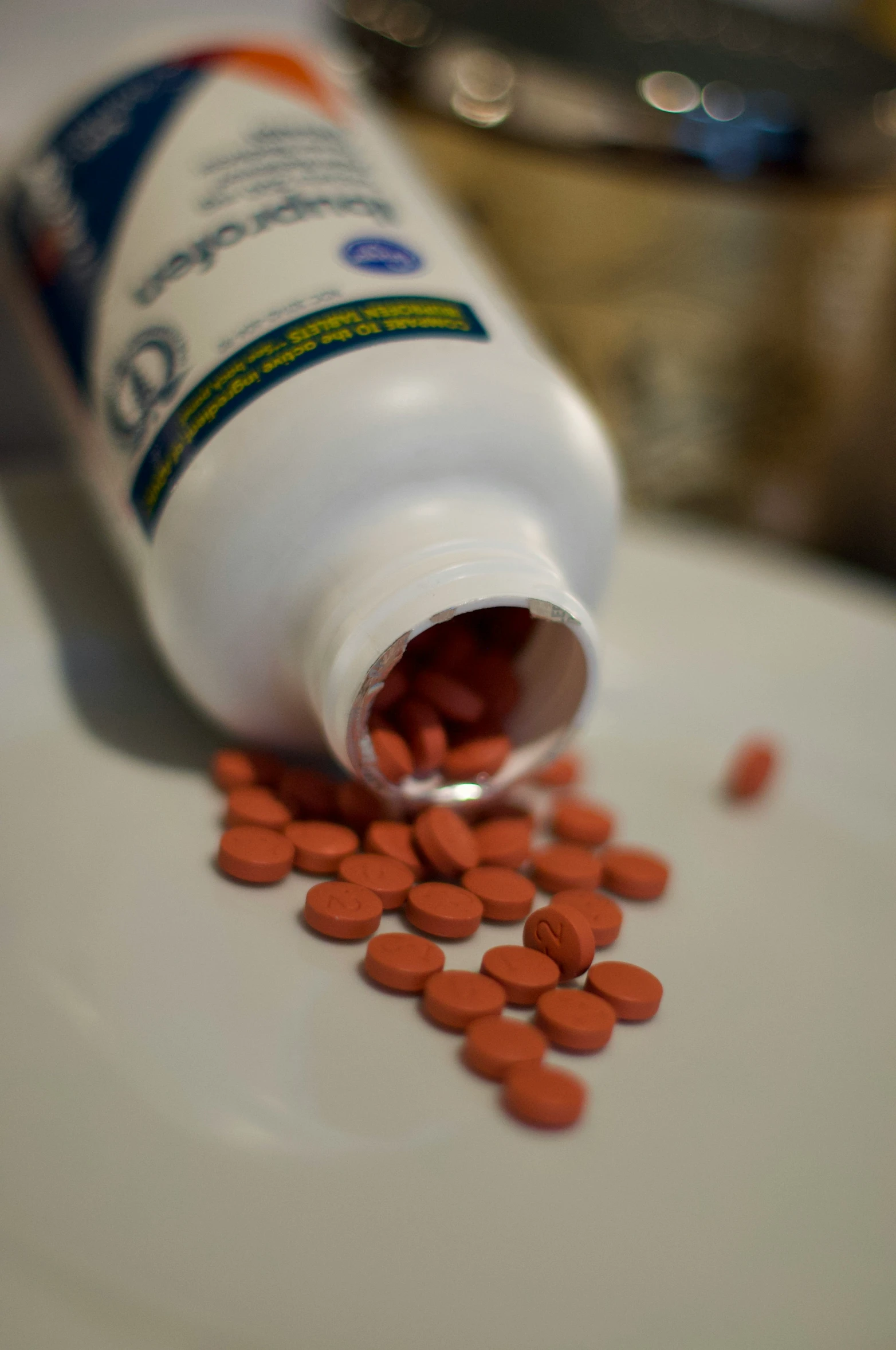 a bottle of pills sits on the plate with spilled pills