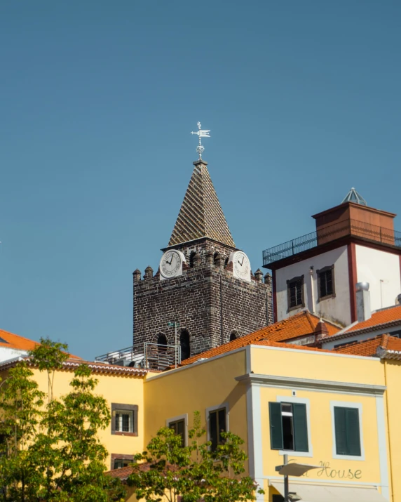 a building with many clocks on top and a cross on it