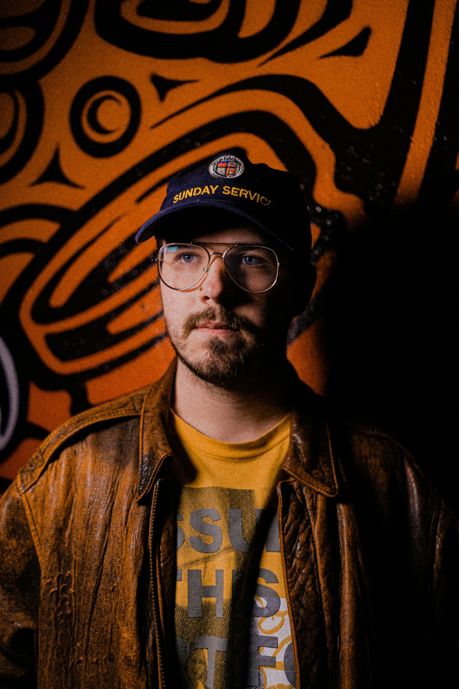 man in glasses, wearing a hat with native designs