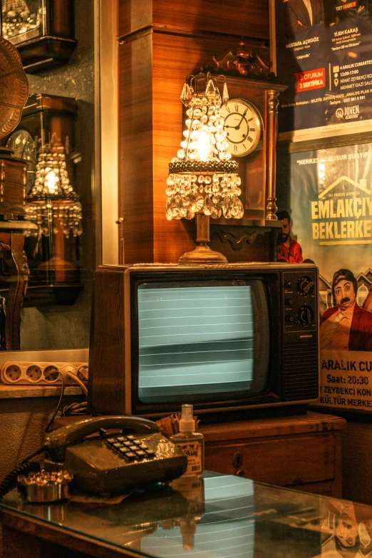 an old fashioned tv sitting in front of a giant clock