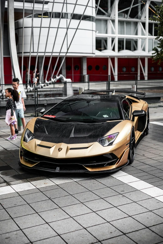 a gold sports car parked on a street next to people