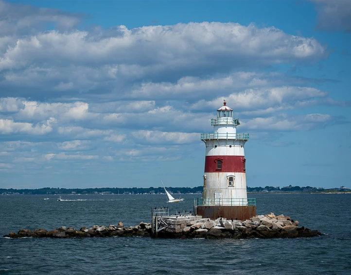 there is a small lighthouse sitting on the rocks