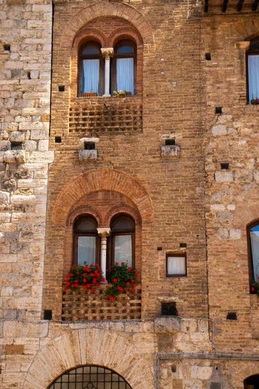 a brick building with windows and flowers in a flower box