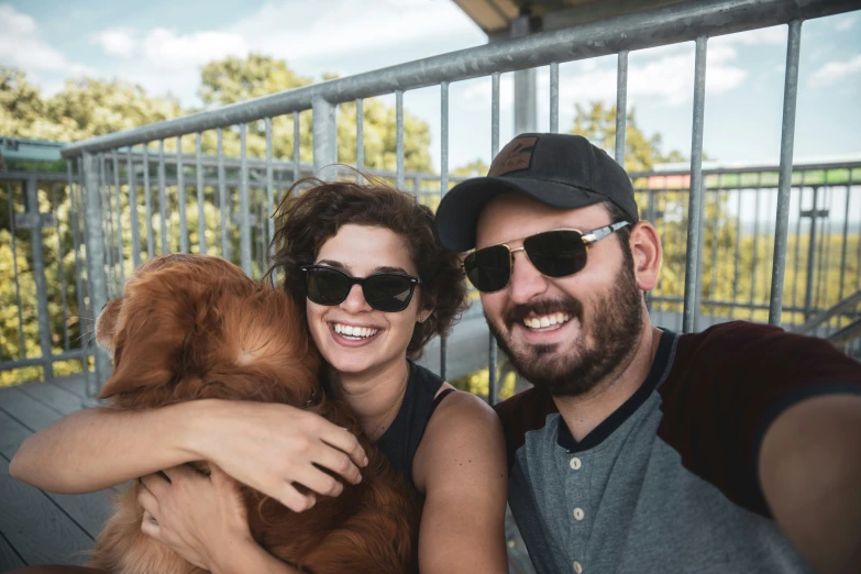 a couple holding a puppy and smiling for the camera