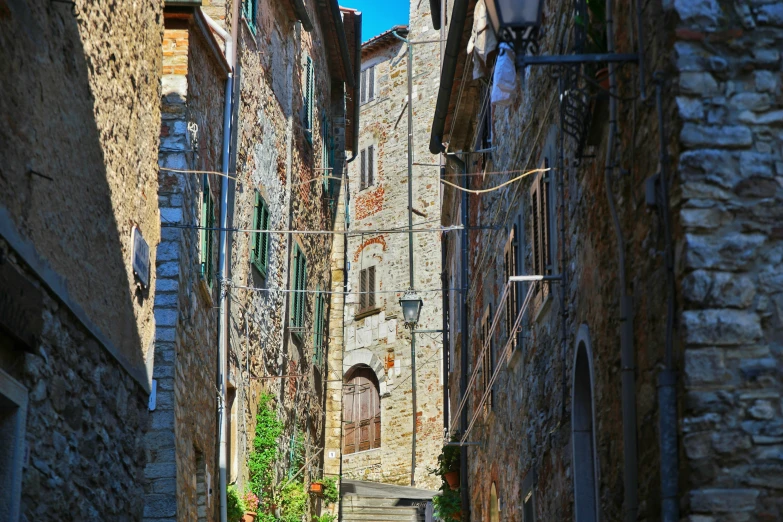 a narrow alleyway with stone buildings and small courtyard