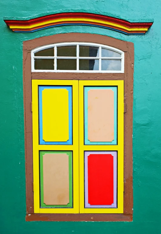 a brightly colored painted window in an old green building