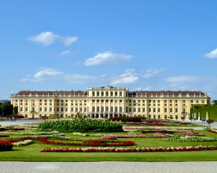 large palace with multiple lawn areas and many flowers