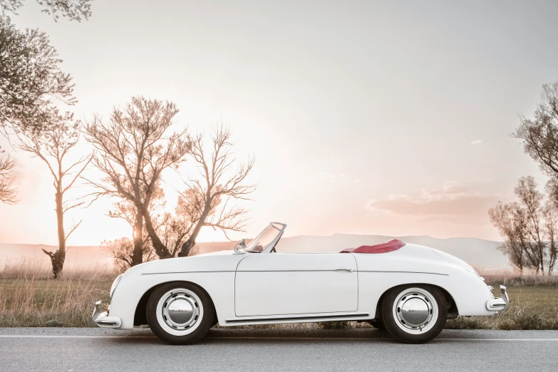 an old style convertible car parked on the side of a road