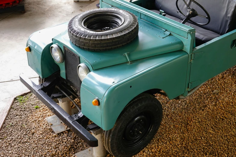 an old green jeep is parked in the driveway