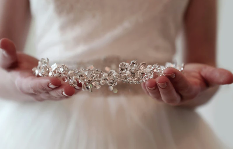 a woman is holding out her hands with a necklace on