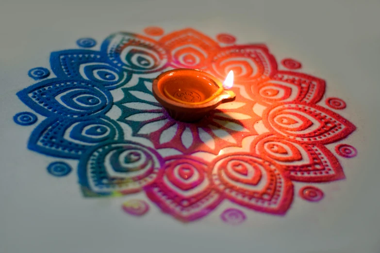 a candle with a pattern in the center surrounded by candles