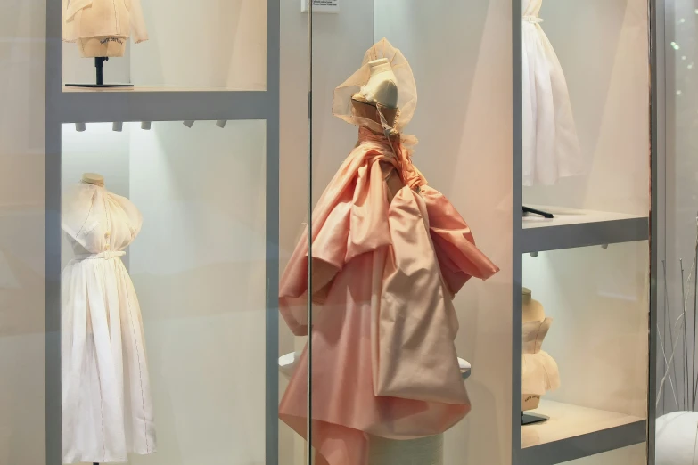 a display case containing dresses for dolls