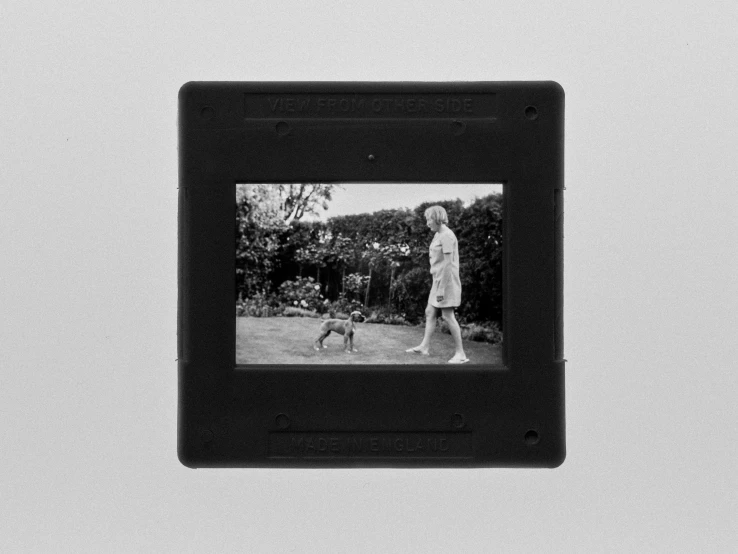a black and white po of a person holding a dog in the yard