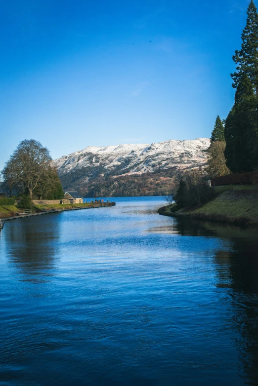 a lake and snow covered mountains reflect the sun