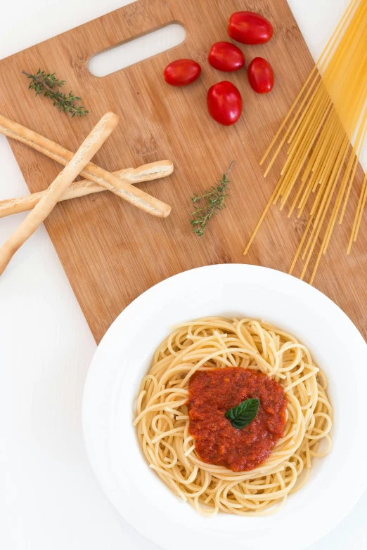 the table is set with pasta, tomatoes and parmesan cheese