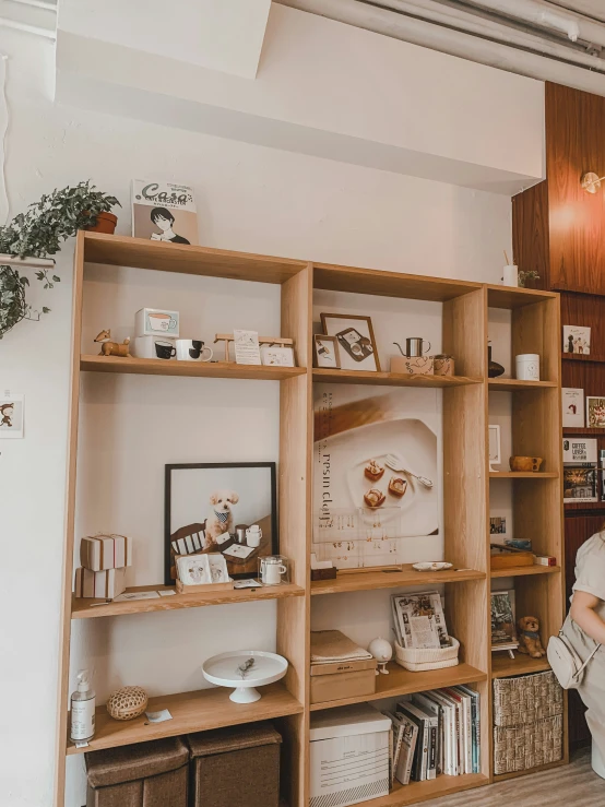 a woman holding a purse and standing in front of a bookshelf filled with books