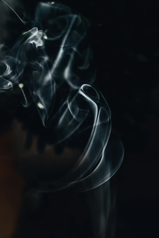 some white smoke moving across a black background