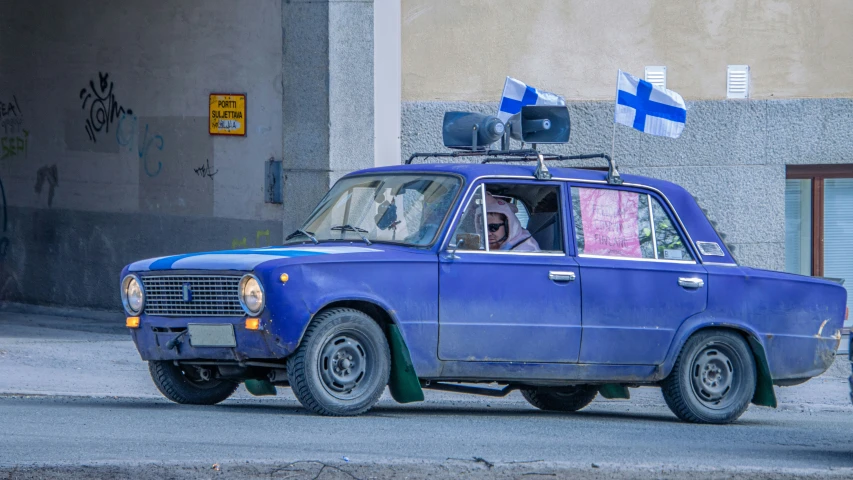 there is an old blue car with a antenna on top