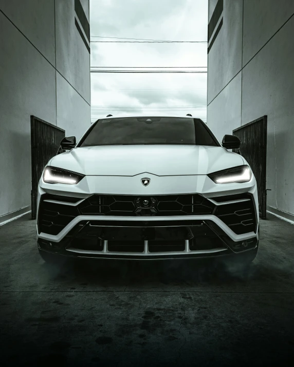 the rear end of a white car with a large grille on it