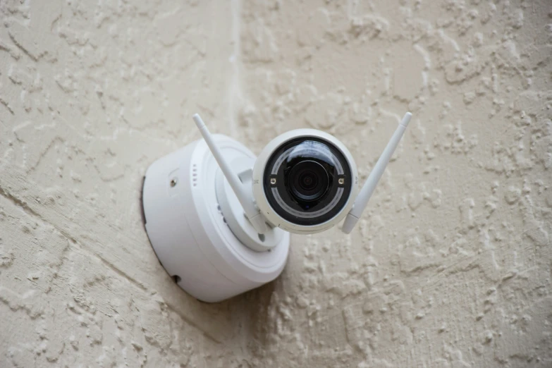 a surveillance camera on the wall of a building
