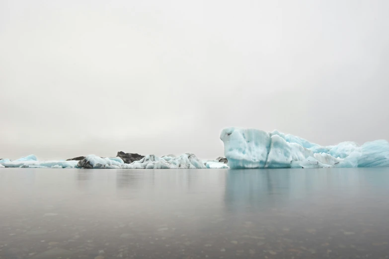 some very ice covered rocks on a large body of water