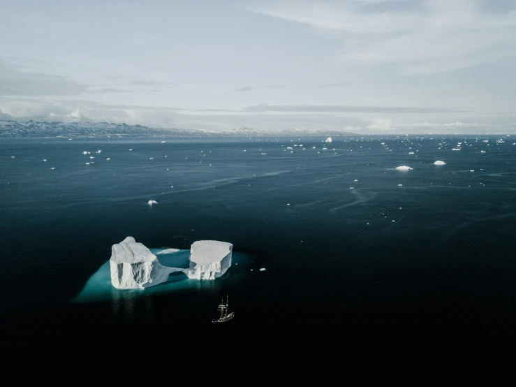 an iceberg in the water near some cliffs