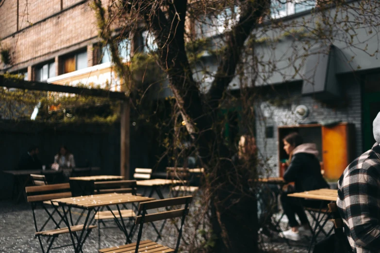 two people sitting at picnic tables with the building in the background